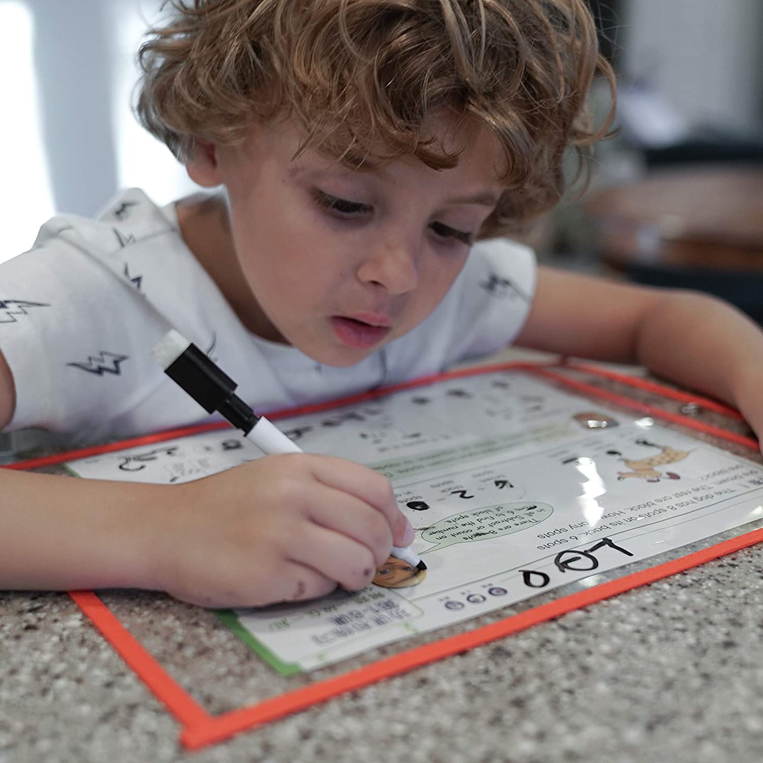 Child coloring a worksheet through a dry erase pocket